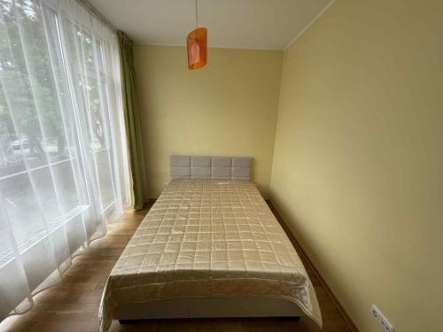 a small bed in a room with a window at RÜÜTLI City Center Apartment in Pärnu