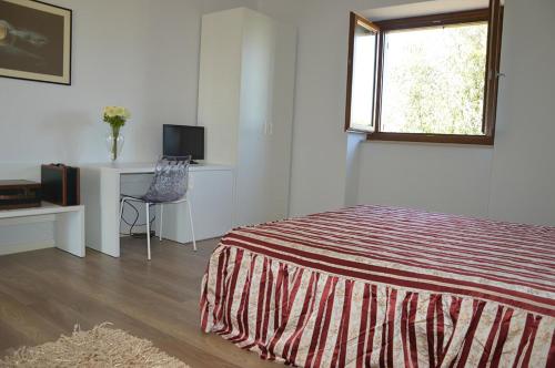 a bedroom with a bed and a desk and a window at Country House Torrenera in Morro dʼOro