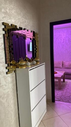 a kitchen with purple lighting and a counter with a sink at Appartement meublé en location nuitée in El Jadida