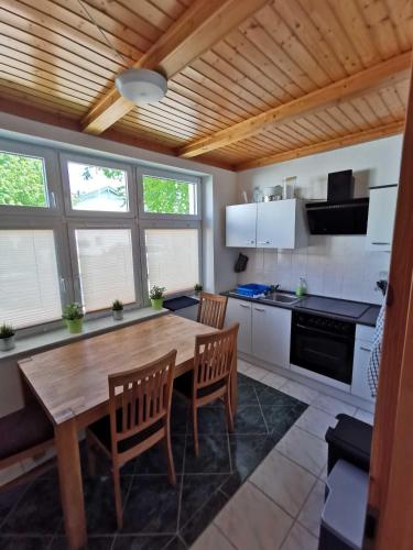 a kitchen with a wooden table and some chairs at Fewo Backboard in Graal