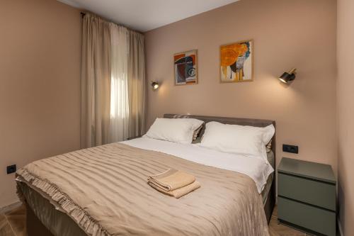 リエカにあるAdastra apartments with private parking and floor heatingのタオルが敷かれたベッドのある寝室