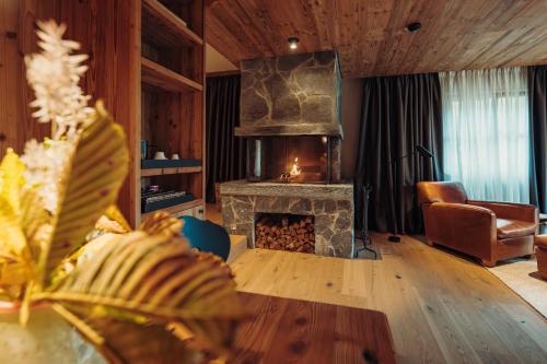 a living room with a fireplace and a couch at Jungbrunn Der Gutzeitort in Tannheim