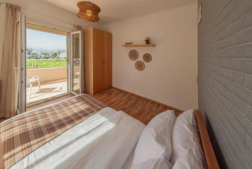 ein Schlafzimmer mit einem Bett und einem großen Fenster in der Unterkunft Roda Luxury Beach House in Roda