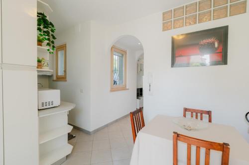 a dining room with a white table and chairs at Forte 25 in Forte dei Marmi