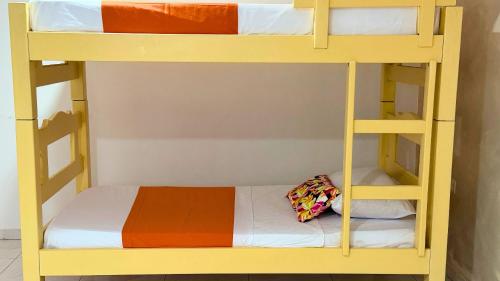 a yellow bunk bed with a pillow on the bottom bunk at Taybo House by St Hoteles in San Andrés