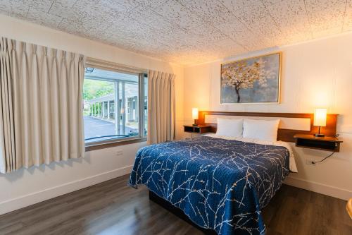 a hotel room with a bed and a window at Mount Coolidge Motel in Lincoln