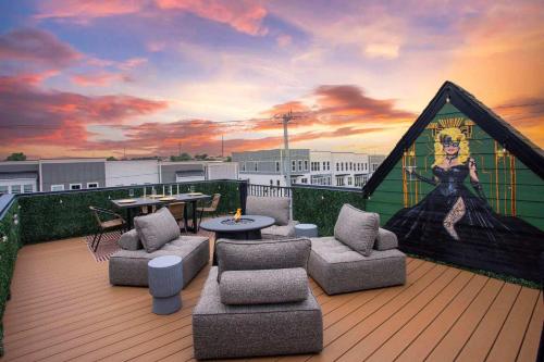 eine Dachterrasse mit Möbeln und einem Gemälde einer Frau in der Unterkunft Rooftop Deck Hot Tub Fire pit Sleeps 10 in Nashville