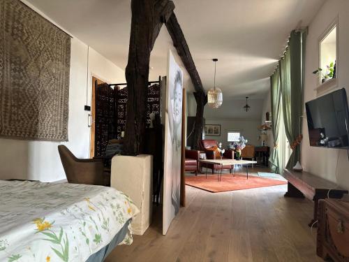 a bedroom with a bed and a living room at Onder de paardenkastanje in Empe