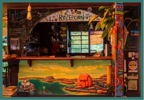a bar with a painting on the wall at CASA KAYAM Art Hostel Coliving Coworking in Guatapé