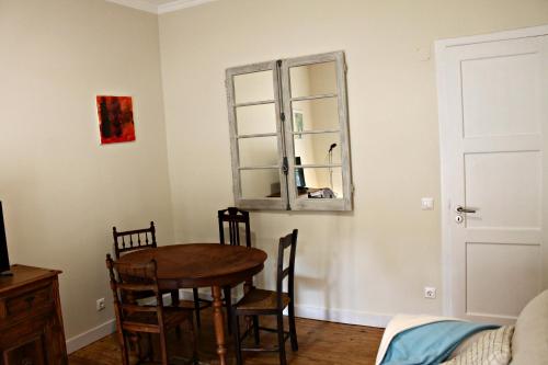 una sala da pranzo con tavolo, sedie e specchio di Sintra - Casa da Portela a Sintra