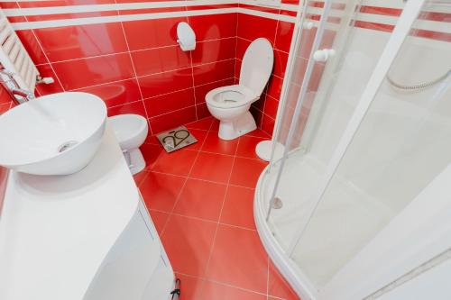 a red bathroom with a toilet and a shower at Forte 25 in Forte dei Marmi