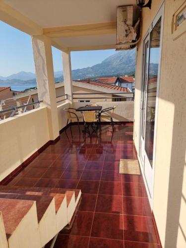 a balcony with a table and chairs on it at Apartments and Studios Anicic in Utjeha