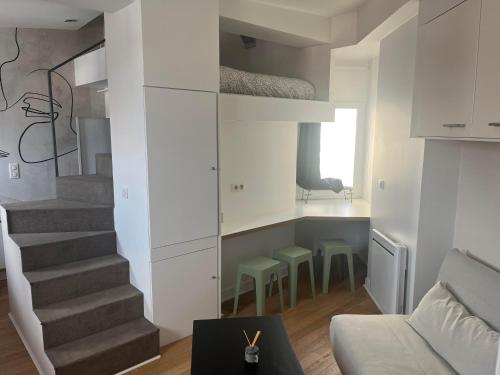 - un salon avec un escalier, un canapé et une table dans l'établissement Lara Home, centre reims, à Reims