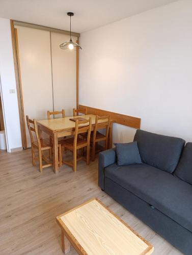 un salon avec un canapé bleu et une table dans l'établissement Appartement avec vue aux pieds des pistes, à Saint-Étienne-en-Dévoluy