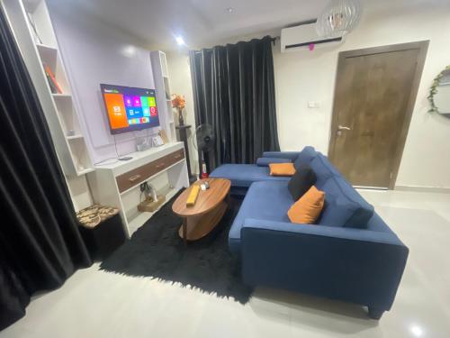 a living room with a blue couch and a tv at Spot1 in Ilado