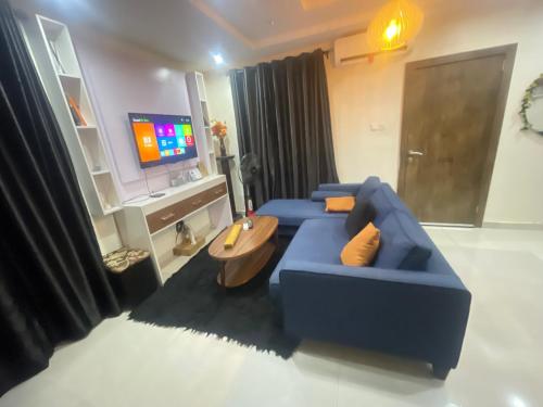 a living room with a blue couch and a tv at Spot1 in Ilado