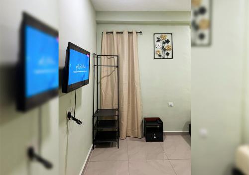 a living room with a tv and a room with at Hotel EC Inn in Sepang