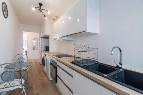 une cuisine avec des armoires blanches et un évier dans l'établissement 2 Bedroom Ocean view Apartment, à Nice