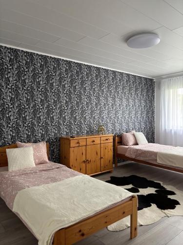 a bedroom with two beds and a patterned wall at Cozy apartment in Haapsalu in Haapsalu