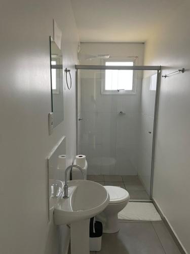 a bathroom with a shower and a toilet and a sink at Hotel Califórnia Cruz Alta in Cruz Alta