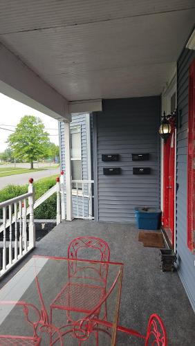 a red chair sitting on the porch of a house at Beautiful downstairs 1bed 1bth charmer- Pet Friendly in Michigan City