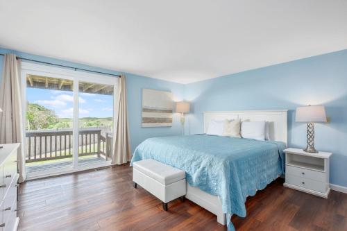 1 dormitorio azul con 1 cama y balcón en 19 Bob White Lane South Harwich Cape Cod - Summer Wind, en South Harwich