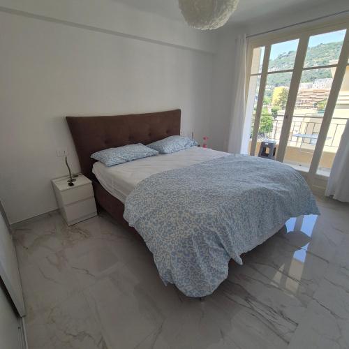 une chambre avec un lit avec une couette bleue dans l'établissement Bahri House, à Nice