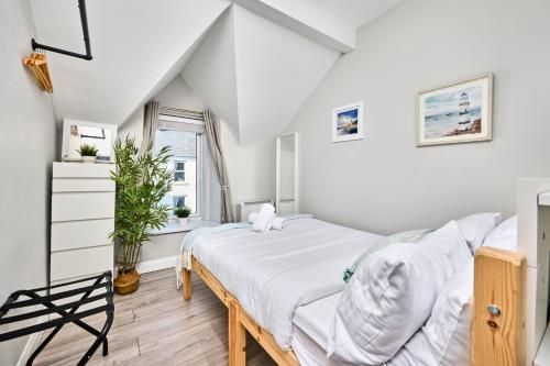 ein weißes Schlafzimmer mit einem Bett und einem Fenster in der Unterkunft Princess Blue 3 ~ Portrush by the Sea in Portrush