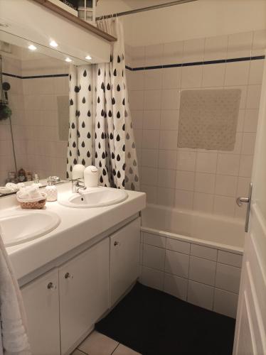 La salle de bains blanche est pourvue d'un lavabo et d'une baignoire. dans l'établissement Bordeaux, à Bordeaux