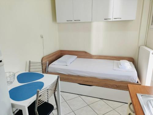 une petite pièce avec un lit et une table dans l'établissement Ocean Blue, à PalaiónTsiflíkion