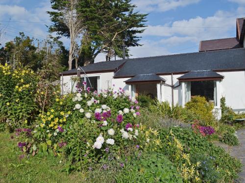 a garden with flowers in front of a house at Haulfryn Cottage in Menai Bridge