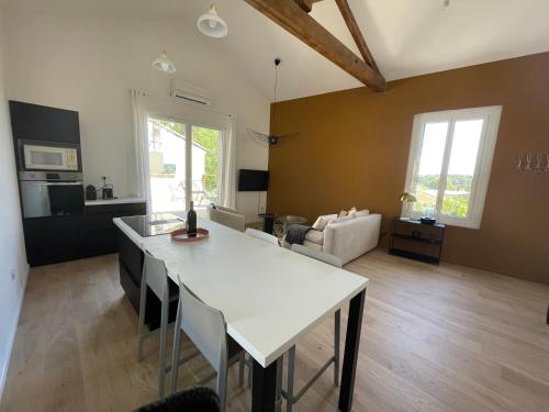 un salon avec une table blanche et un canapé dans l'établissement Appartement standing mas en pierre traditionnel, à Clapiers