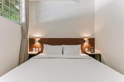 a bedroom with a white bed and a window at Wenceslao By Homirent in Querétaro