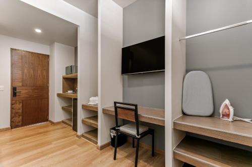 a room with a desk with a tv and a chair at Wenceslao By Homirent in Querétaro
