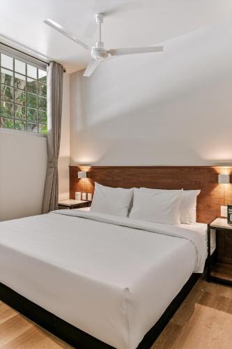 a large white bed in a room with a window at Wenceslao By Homirent in Querétaro