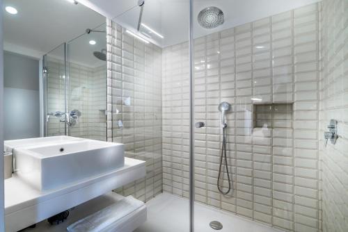 a white bathroom with a sink and a shower at Villa Vasco da Gama in Cascais