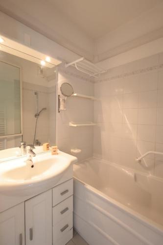 une salle de bain blanche avec un lavabo et une baignoire dans l'établissement Antibes Les Pins - Apt 4 Per - Parc Exflora - Pool, à Antibes