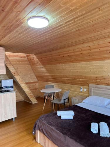 a bedroom with a bed and a table in a room at Hotel Zhara in K'obulet'i