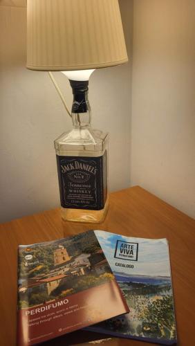 a table with a lamp and a book and a magazine at Domus in Horto in Perdifumo