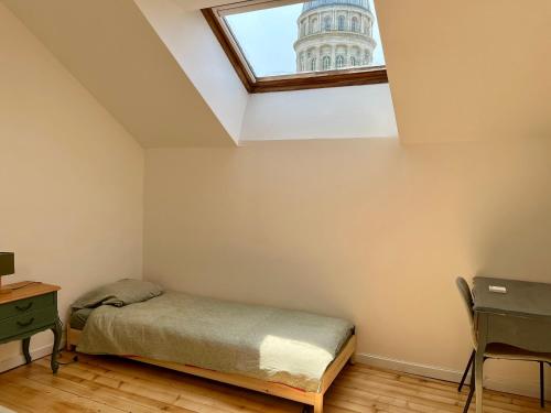 une chambre avec un lit et une fenêtre dans l'établissement Appartement dans le vieux Boulogne sur Mer, à Boulogne-sur-Mer
