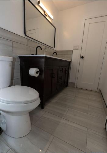 a bathroom with a toilet and a sink and a mirror at Calm and collective in Brooklyn