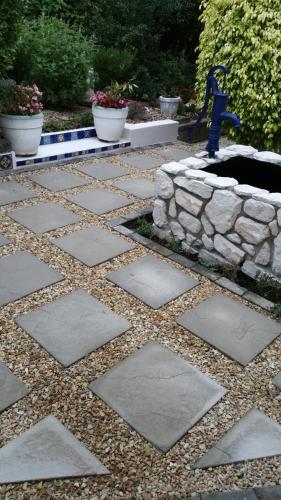 a stone walkway with a stone wall in a yard at Bergview Guesthouse Swellendam in Swellendam