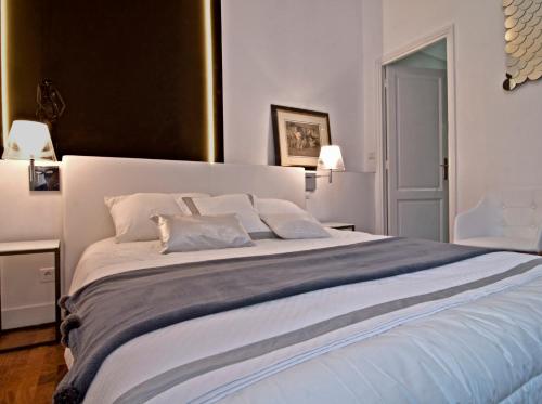1 dormitorio con 1 cama blanca grande y 2 almohadas en Le Boudoir 137, en Burdeos