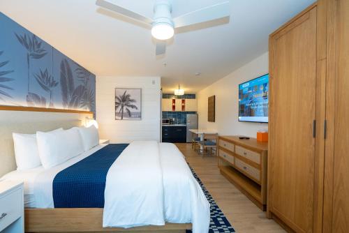 a bedroom with a bed and a desk and a television at Sunshine Suites Resort in George Town