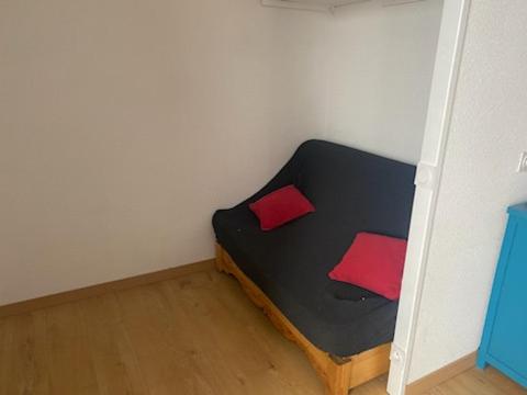 un lit noir avec deux oreillers rouges dans une chambre dans l'établissement Appartement Puy Saint Vincent 1700, à Puy-Saint-Vincent