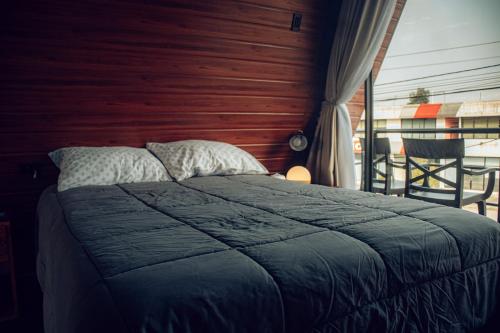 a bedroom with a bed with a wooden wall at Tena Tower House TTH in Tena