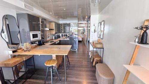 une cuisine avec un comptoir et des tabourets dans une pièce dans l'établissement Village naturiste, Port-Ambonne, appartement 42 m2, Le luxueux., au Cap d'Agde