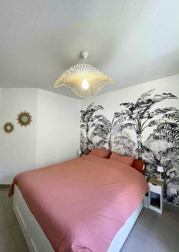 une chambre avec un grand lit avec une couverture rose dans l'établissement Le palmier Seynois, à La Seyne-sur-Mer