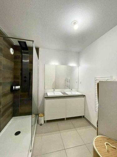 une salle de bain blanche avec un lavabo et une douche dans l'établissement Le palmier Seynois, à La Seyne-sur-Mer