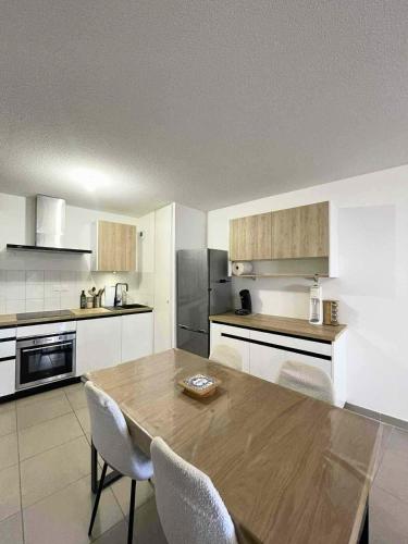 une grande cuisine avec une table et des chaises en bois dans l'établissement Le palmier Seynois, à La Seyne-sur-Mer